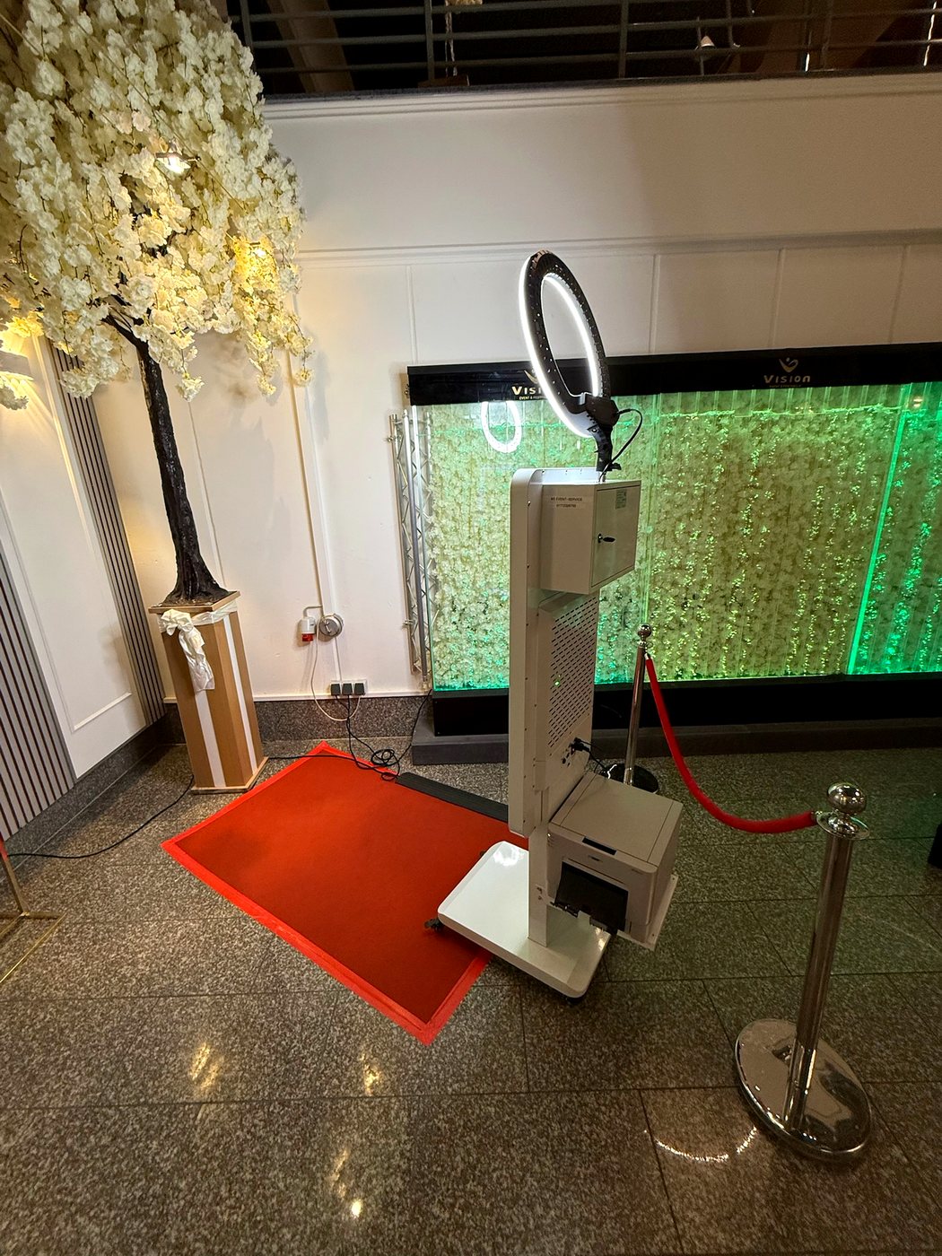 Fotobox mit weißem Blütenbaum und rotem Teppich