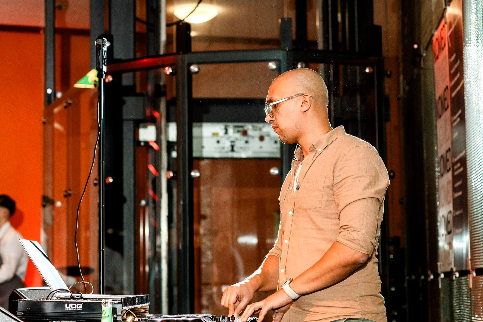 Adam Gansania am DJ-Pult im warmen Seitenlicht