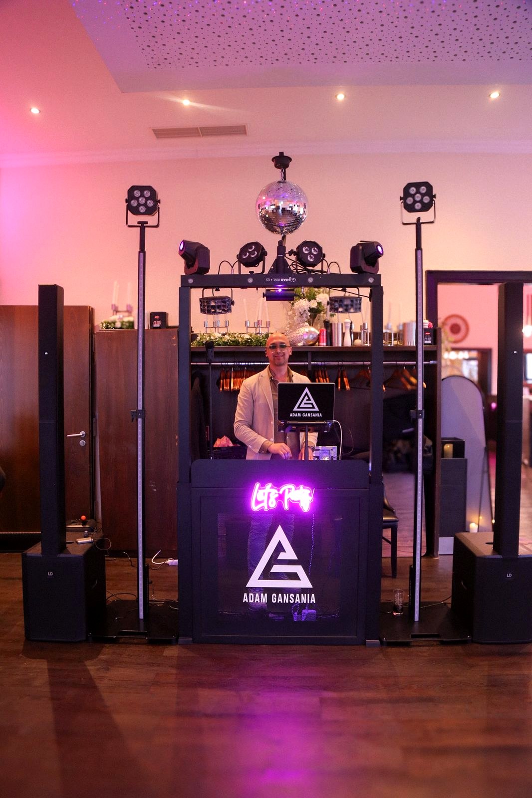 DJ-Setup mit Dreiecks-Deko und violetten Uplights