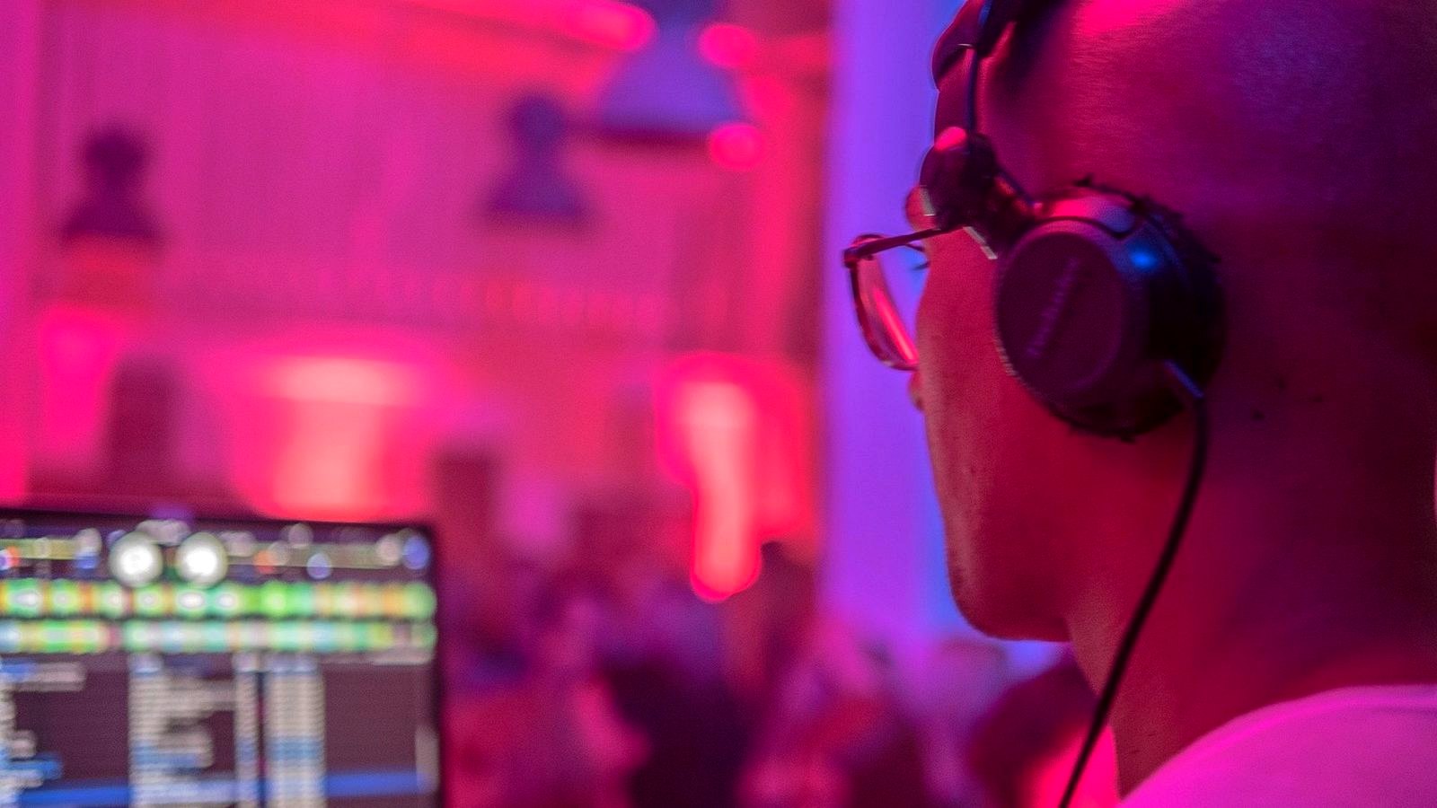 Adam Gansania mit Kopfhörern im Magenta-Licht